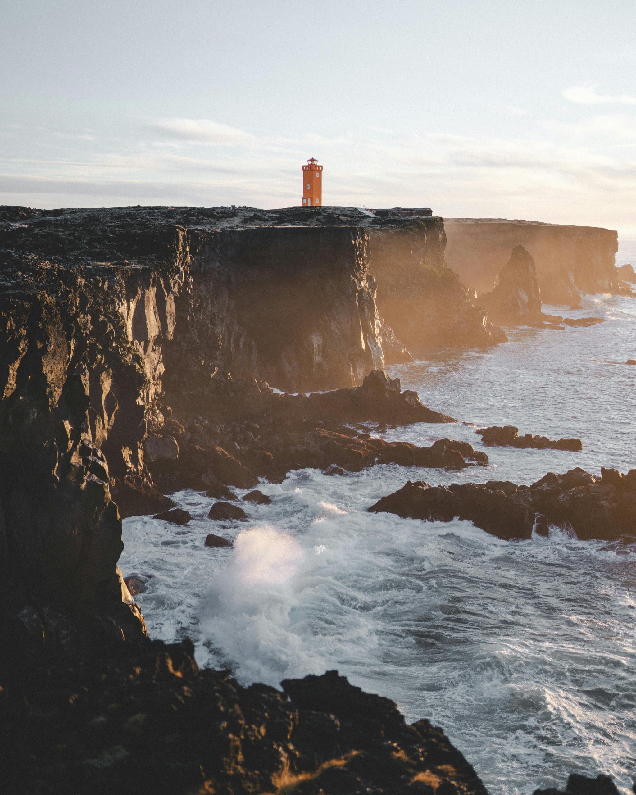 Falaise en Islande avec phare au loin